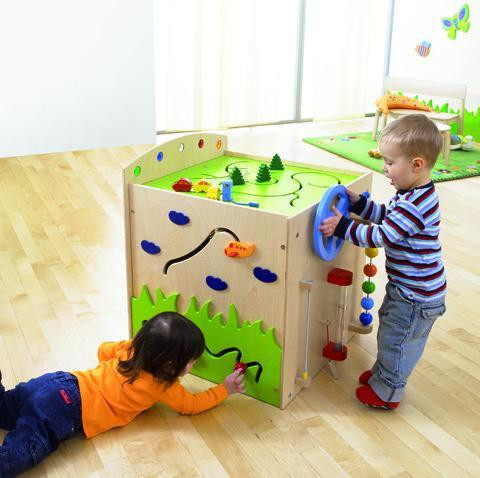 HABA Pro Multi Sensory Learning Cube, children playing with a multi-sensory educational cube featuring various textured surfaces, colorful shapes, and interactive elements for skill development.