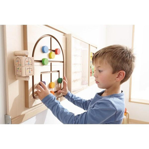 HABA Pro Labyrinth Maze Sensory Wall Toy, young boy playing with a wooden maze puzzle mounted on a wall.
