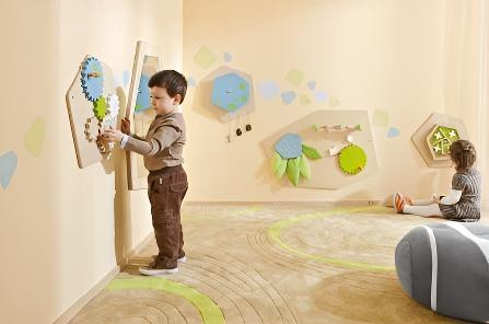 HABA Pro Grow.upp Ball Labyrinth Sensory Activity Wall Panel, children playing and engaging with the sensory activity wall in a playroom.