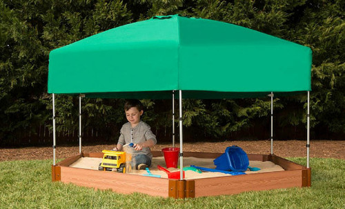 Frame It All Hexagon Sandbox Kit with Telescoping Canopy & Cover, 7' x 8' x 5.5", outdoor sandbox with green canopy, wooden frame, and children playing with toys inside on grass.