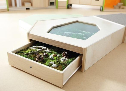 HABA Pro Grow.upp Display Case Play Platform "A", a wooden play platform with a built-in glass window and a flowerbed with plants and decorations.