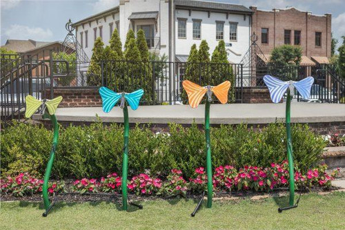Freenotes Butterfly Musical Bell Ensemble - Set of 4, colorful butterfly-shaped musical bells mounted on green stems in a garden setting.
