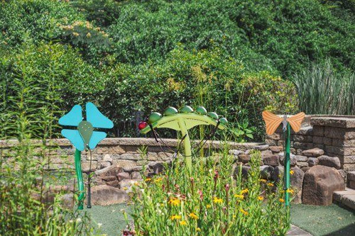 Freenotes Metamorphosis Ensemble Musical Set, outdoor musical instruments in a garden setting with greenery and flowers