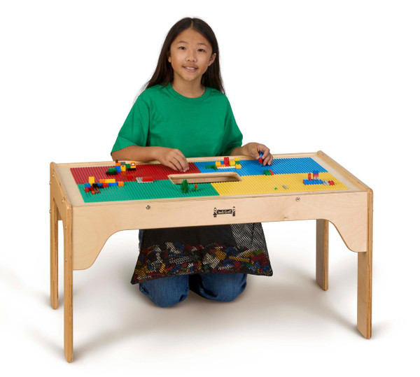 Jonti-Craft Wooden LEGO® Rectangle Storage Table, a sturdy wooden educational table with a LEGO® compatible surface, shown with a child playing and building with LEGO® bricks.