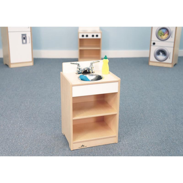 Whitney Brothers Let's Play White Toddler Play Sink, wooden toddler play sink with stainless steel basin, yellow soap bottle, and blue scrub brush in a preschool setting.