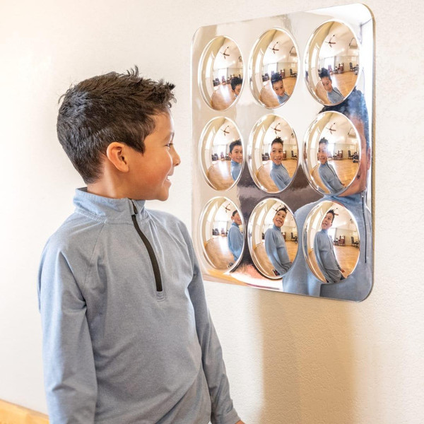 SPARK & WOW Bubble Sensory Mirror - 9 Large Bubbles, young boy looking at the mirror with multiple reflective bubbles on a wall.