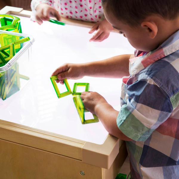 Guidecraft LED Tabletop Lightbox, children playing with green magnetic tiles on a white illuminated surface.