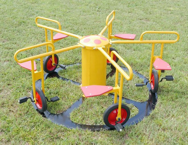 Infinity Playgrounds Infinity Cycle 5 Seat Carousel with Pedal Track, bright yellow and red playground equipment for children on grass field.