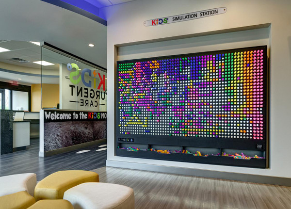 LiteZilla Giant Lite Brite 8' x 6' Light Wall, colorful light wall display in a kids' simulation station.