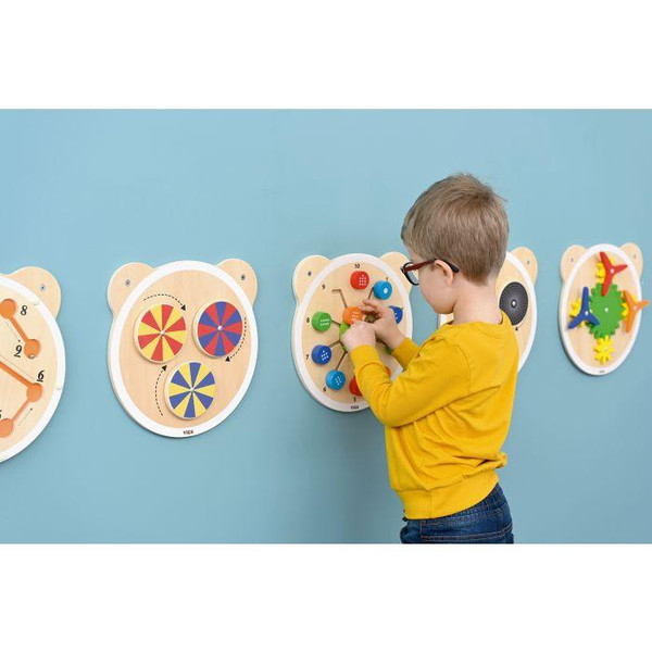 Moje Bambino Sensory Wall Toys - Set of 6, colorful wooden sensory and activity toys mounted on a wall with a child playing.