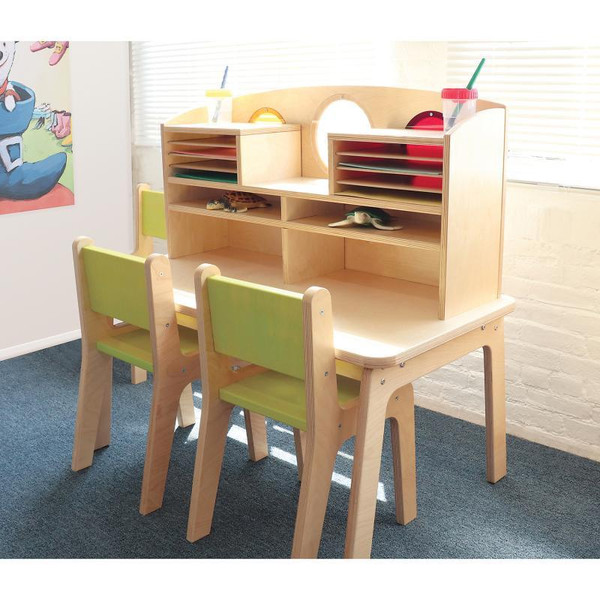 Whitney Brothers Whitney Plus Porthole Desk, wooden children’s desk with a built-in shelf and circular cutouts, accompanied by two green chairs.