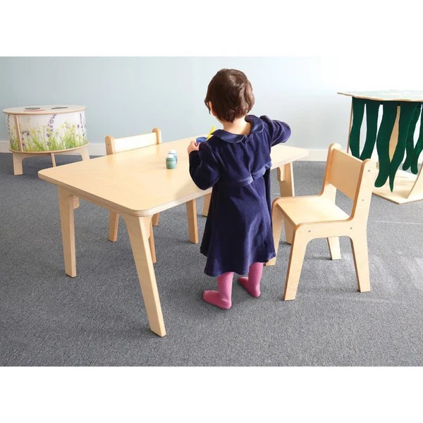 Whitney Brothers Whitney Plus Rectangle Classroom Table - 22H, child standing at educational wooden table in classroom setting.