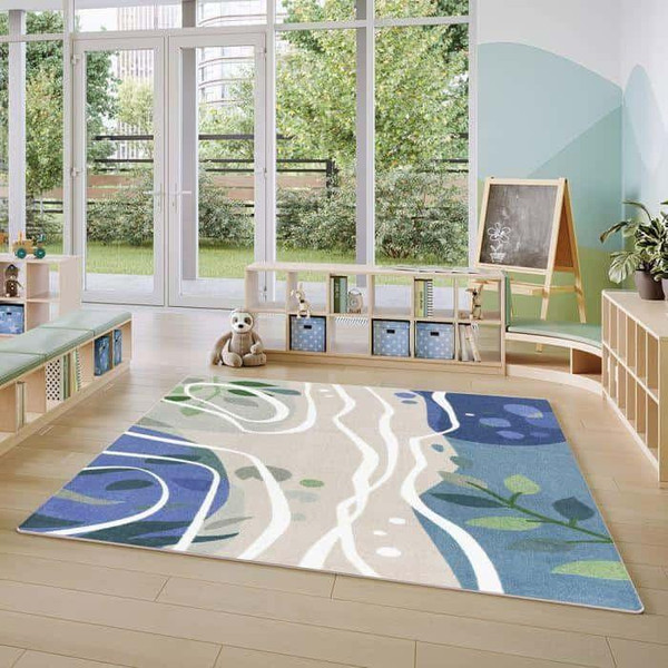 Playscapes Still Waters™ Designer Classroom Carpet, colorful decorative rug with abstract water and nature design in a bright playroom with large windows and educational furniture.