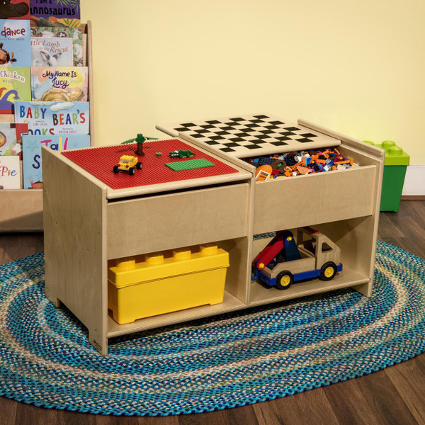 Wood Designs Build-N-Play Table with Checkerboard, wooden play table featuring a red Lego surface and a chessboard top, filled with building blocks and toys for children.