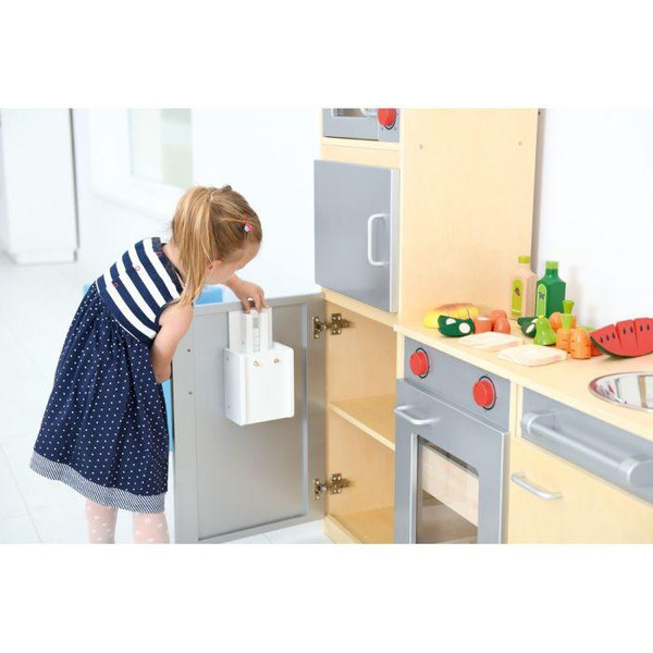 Moje Bambino Complete Dramatic Play Kitchen Set #1, young girl playing with a miniature toy kitchen set including mock appliances and utensils in a bright play area.