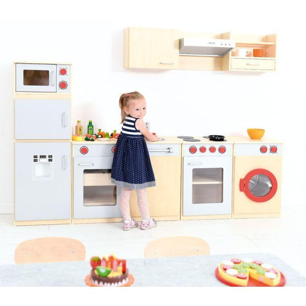 Moje Bambino Complete Dramatic Play Kitchen Set #1, a child's play kitchen with realistic appliances including microwave, oven, stove, and washing machine, styled in light wood and white with red accents, set in a bright playroom.