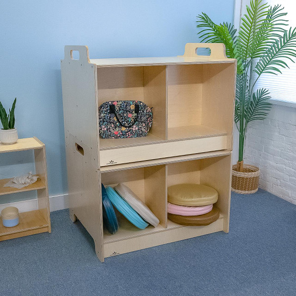 Whitney Brothers Stack-Able™ Table, wooden educational storage and activity table with multiple compartments and a sliding drawer, placed in a classroom setting with plants and other furniture.