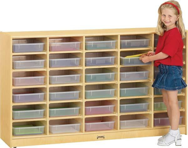 Jonti-Craft 30 Tray Storage Cubbie Cabinet with Paper Trays, a wooden storage unit with multiple transparent paper trays and a smiling young girl in a red shirt and blue denim skirt organizing the trays.