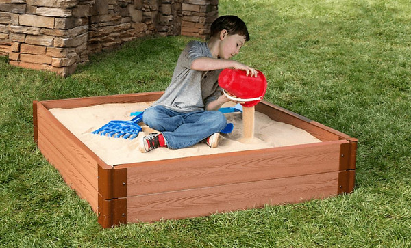 Frame It All Square Sandbox - 4' x 4' x 11", children playing in a wooden sandbox with sand and toys outdoors.