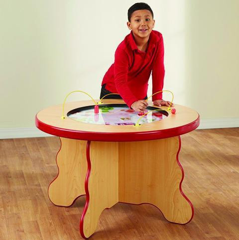 Playscapes Fruits & Veggies Children's Play Table, a wooden kids' play table with a colorful interactive fruit and vegetable-themed surface and a smiling young boy playing.