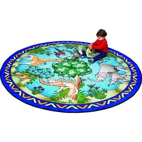 Playscapes Animal Families Kids Area Carpet, a round colorful play carpet featuring various animal illustrations and forest scenery, with a child sitting on it.