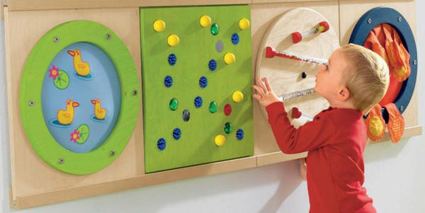 HABA Pro Acrylic Gears Sensory Wall Activity Panel, kid playing with wooden gear maze on sensory wall panel.