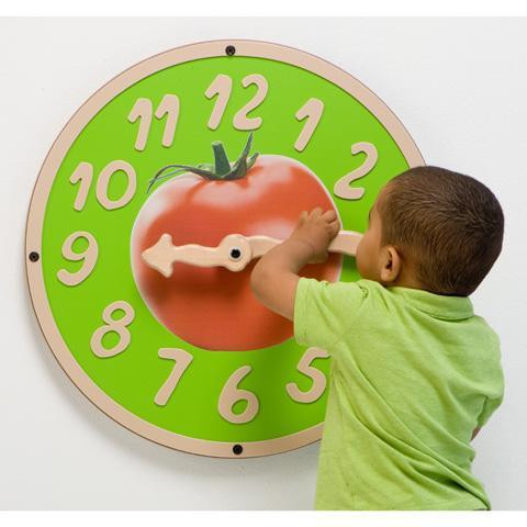 Playscapes Tomatoe Time Clock Wall Toy, a colorful educational wall clock featuring a large red tomato in the center and a young child interacting with it.