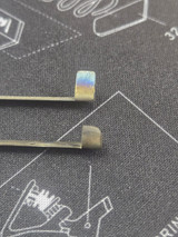 A raw trip bar vs one that has been prepared, shortened tab, radiused edge and chamfers. this can be done on a belt sander, grinding wheel, or with a Dremel tool.