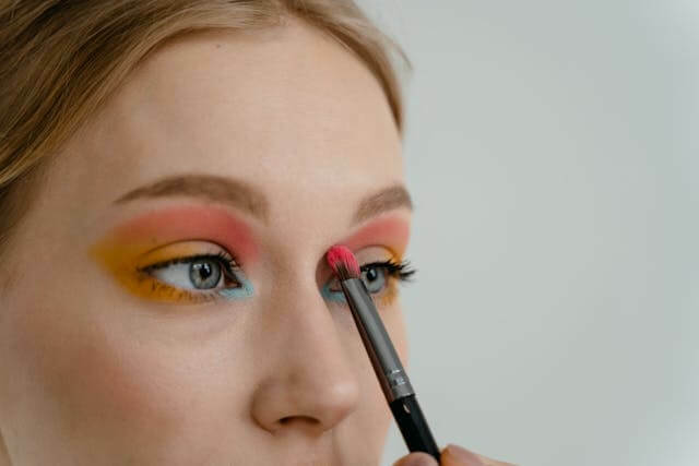 Woman applying colorful eyeshadow