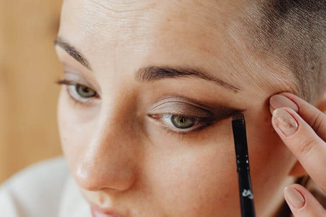Closeup of woman applying dark eyeshadow