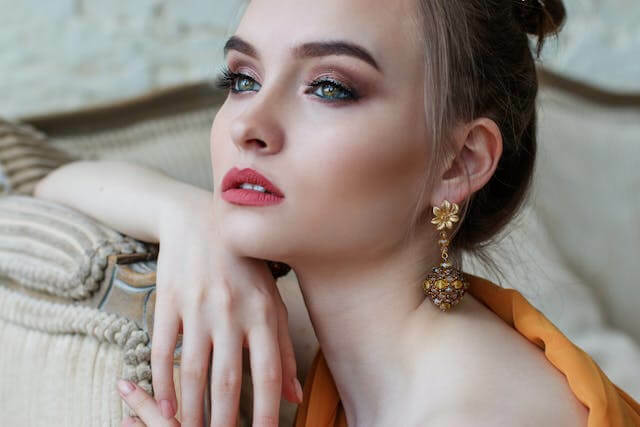 Woman looks off camera wearing lipstick and eyeshadow 