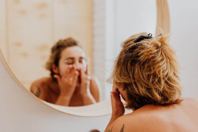 Woman with oily skin washing her face