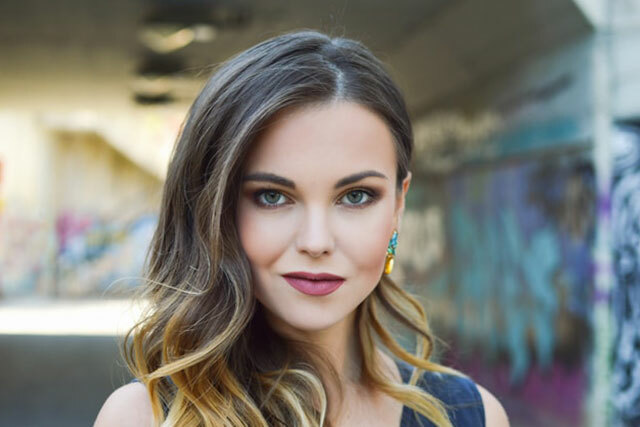 Woman outside smiles while wearing makeup