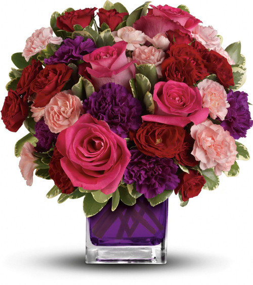 Pure romance. Hot pink roses and dark red spray roses are brightly arranged inside our violet cube.