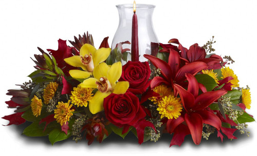 Graceful. Glowing. Gorgeous. This stunning centerpiece will make setting the mood and the Thanksgiving table nothing less than perfect. Fall's most fabulous flowers surround a candle inside hurricane glass. Now that's true class.
