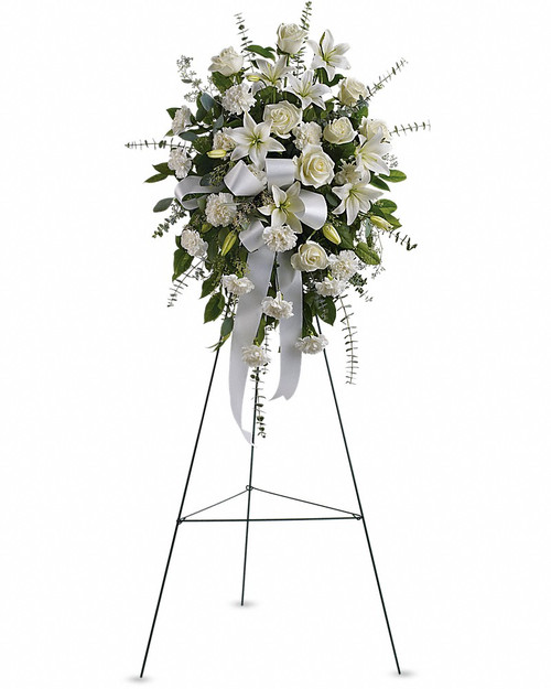 Stunning in its simplicity, this gorgeous spray of white roses, lilies and carnations decorated with white satin ribbon is a tasteful way to express your sympathy.   The elegant spray includes white roses, white Asiatic lilies and white carnations, accented with assorted greenery.