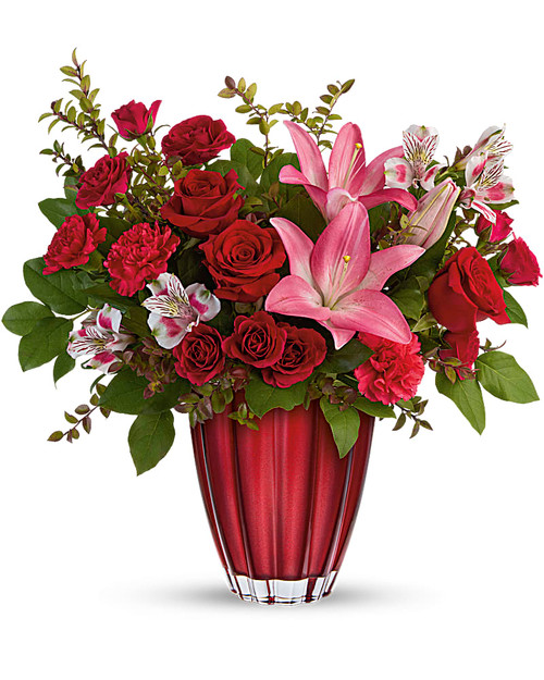 Shimmering with a metallic ombre finish and bursting with a lavish bouquet of classic red roses and pink lilies, this unique European glass vase is a Valentine's Day gift they'll cherish forever.
This arrangement includes red roses, dark pink spray roses, pink asiatic lilies, light pink alstroemeria, hot pink carnations, red huckleberry and lemon leaf.