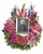 Keep fond memories close to your heart with this lovely feminine floral wreath. It's perfect to surround a framed photo of the departed.
Includes a multitude of flowers such as roses and carnations, along with pink gerberas, oriental lilies and snapdragons, purple orchids and asters, plus lavender delphinium. Green button spray chrysanthemums provide beautiful accents.  Please note: Arrangement does not include picture frame.  May be placed on a table or a standing easel.