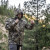 Eberlestock Trinity Peak Jacket 2.0 Mountain Camo Adjusting hood in motion Eberlestock Trinity Peak Jacket 2.0 Mountain Camo Adjusting hood in motion