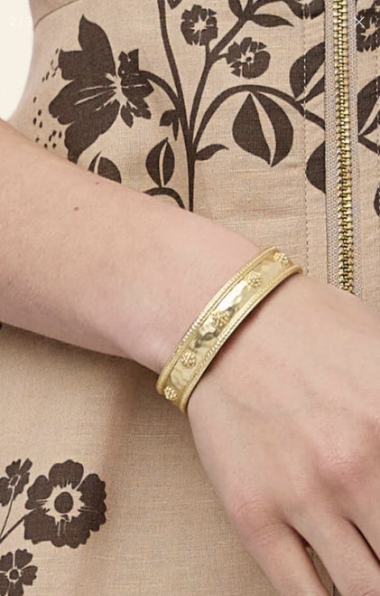 The Spartina 449 Mercer House Gold Cuff Bracelet showcases a sculpted mermaid-scale border, raised floral accents, and a softly hammered silhouette in matte 18kt. gold plating. This adjustable slip-on gold cuff bracelet offers a comfortable fit and timeless style that pairs effortlessly with casual of dressy looks Inspired by Lowcountry charm, it's a versatile statement piece perfect for everyday wear, layering or gifting.
