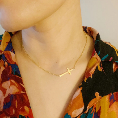 Kayla Side Cross Necklace in 18K gold-plated stainless steel featuring a delicate sideways cross on an adjustable chain.