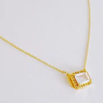 Close-up of the emerald-cut crystal pendant in a gold setting