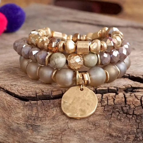 Rose blush beaded bracelet stack featuring faceted glass beads, semi-precious stones, and a hammered gold-tone coin charm.