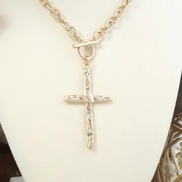 Gold cable chain necklace featuring a hammered cross pendant with clear crystals