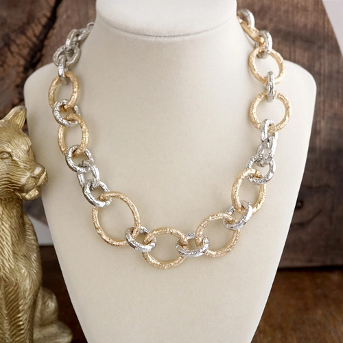 Textured gold and silver chain links on an asymmetrical statement necklace
