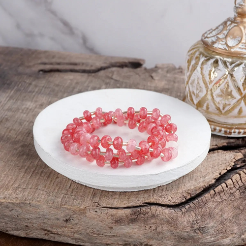 Coral pink glass rondelle beaded stretch bracelet stack with three coordinating bracelets.