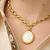 Elegant gold and mother of pearl necklace styled with classic blouse