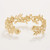 Elegant 18kt. matte gold plated cuff bracelet featuring intricate floral detailing, sparkling glass crystals and classic faux pearls in a refined Lowcountry designer style.