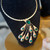The Rayne Necklace is a bold emerald green statement necklace featuring sculpted geometric details, luminous glass crystals, and vintage-inspired 14k gold plated hardware for a timeless, elegant look. Designed for women who love unique boutique jewelry, this adjustable gold collar necklace is perfect for weddings, holiday parties, special occasions, and elevated everyday style