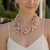 The Cerise Necklace is a beautifully handcrafted statement piece featuring soft blush pink glass beads, hand-knotted onto a silk rope collar with vintage-inspired 14k gold-plated accents. Its romantic color palette and elegant design instantly elevate any outfit, making it perfect for weddings, brunches, special occasions, or everyday sophistication. A timeless accessory for women who love feminine, classic style with a touch of luxury.